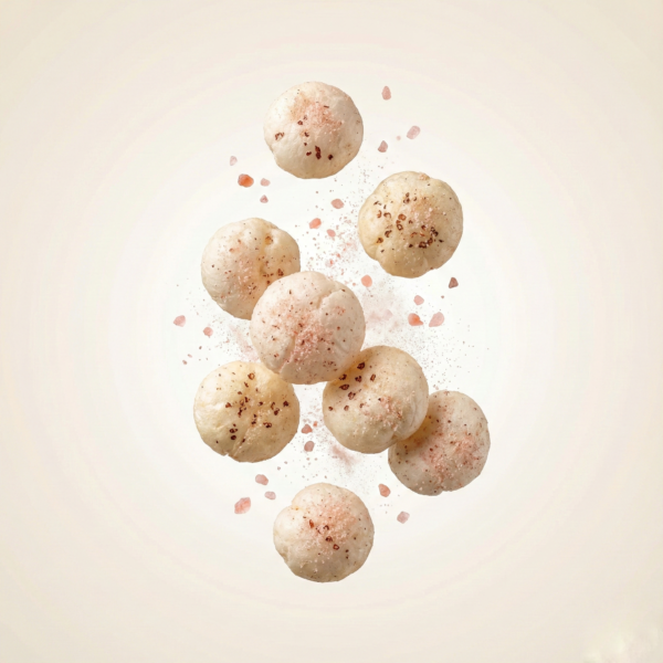 Floating Himalayan salted makhana showing its light texture and subtle salt coating against a soft neutral background