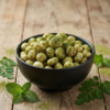 A bowl of mint and moringa flavoured makhana coated with fresh herbal seasoning, styled on a clean surface for a healthy snack look