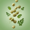 Floating mint and moringa makhana showing its light texture and green herbal coating against a soft background