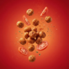 Floating ketchup makhana showing its crunchy texture and rich tomato-flavoured coating against a soft background